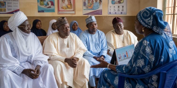 Traditional leaders listen to a public-health worker during a vaccination meeting in Kano