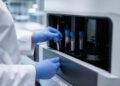 Laboratory technician examining blood culture bottles in a medical lab
