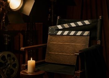 Clapperboard on a director's chair in a dimly lit film studio in tribute mood