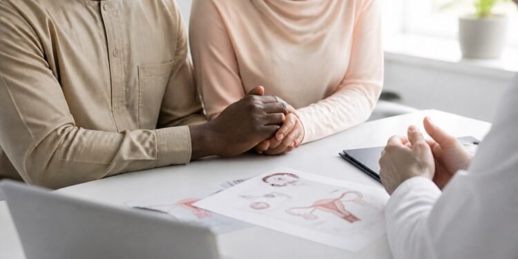 Couple holding hands hopefully in a bright fertility clinic consultation room
