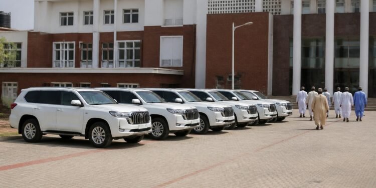 Row of brand-new white luxury SUVs parked at a political party secretariat in Nigeria