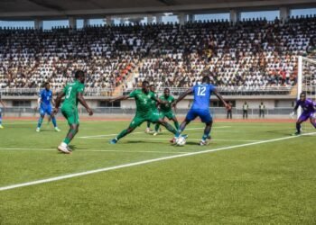 League football match action near the penalty box with packed stadium terraces in Nigeria