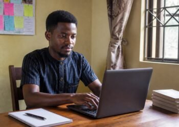 Nigerian entrepreneur registering his new business online on a laptop at home
