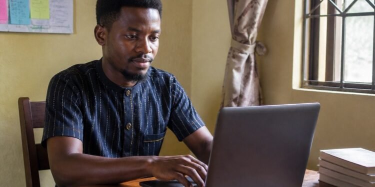 Nigerian entrepreneur registering his new business online on a laptop at home