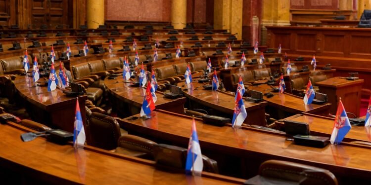 Legislative chamber desks with documents and national flags in soft light